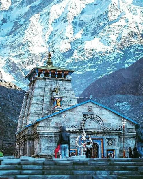 Stone front view of Kedarnath Temple framed by icy mountain walls