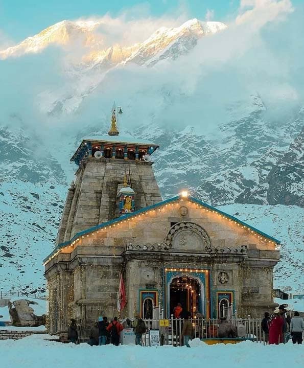 Kedarnath Temple lit softly in a snow-covered setting during cold season conditions